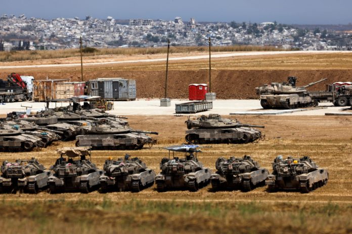Israeli tanks stand near the border between Israel and the Gaza strip, as seen from the Israeli side of the border